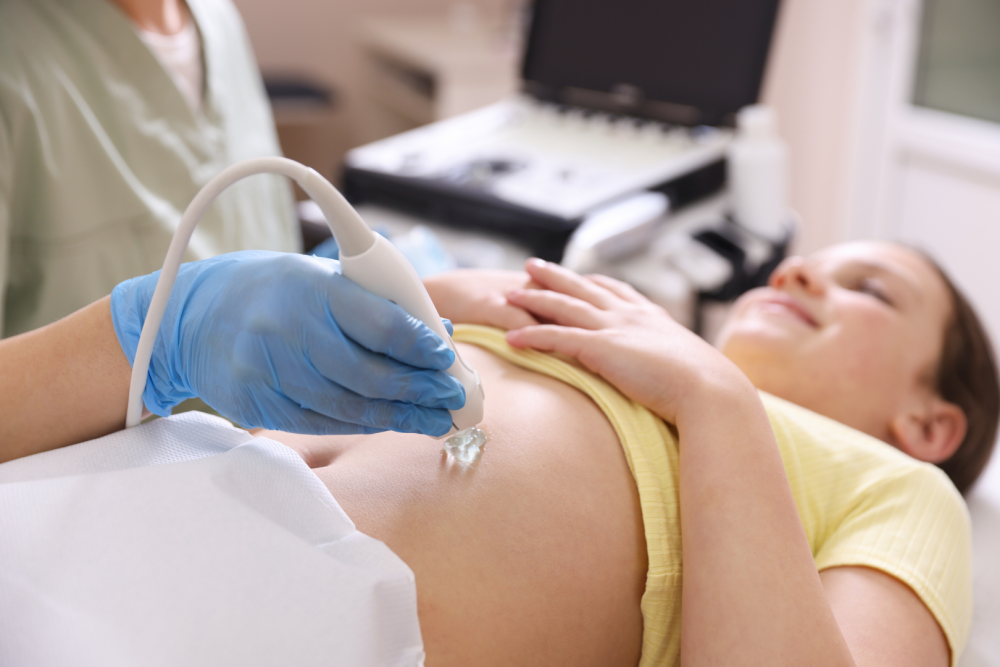 Badanie ultrasonograficzne jamy brzusznej wykonywane głowicą USG, na monitorze aparatu widoczny obraz narządów wewnętrznych