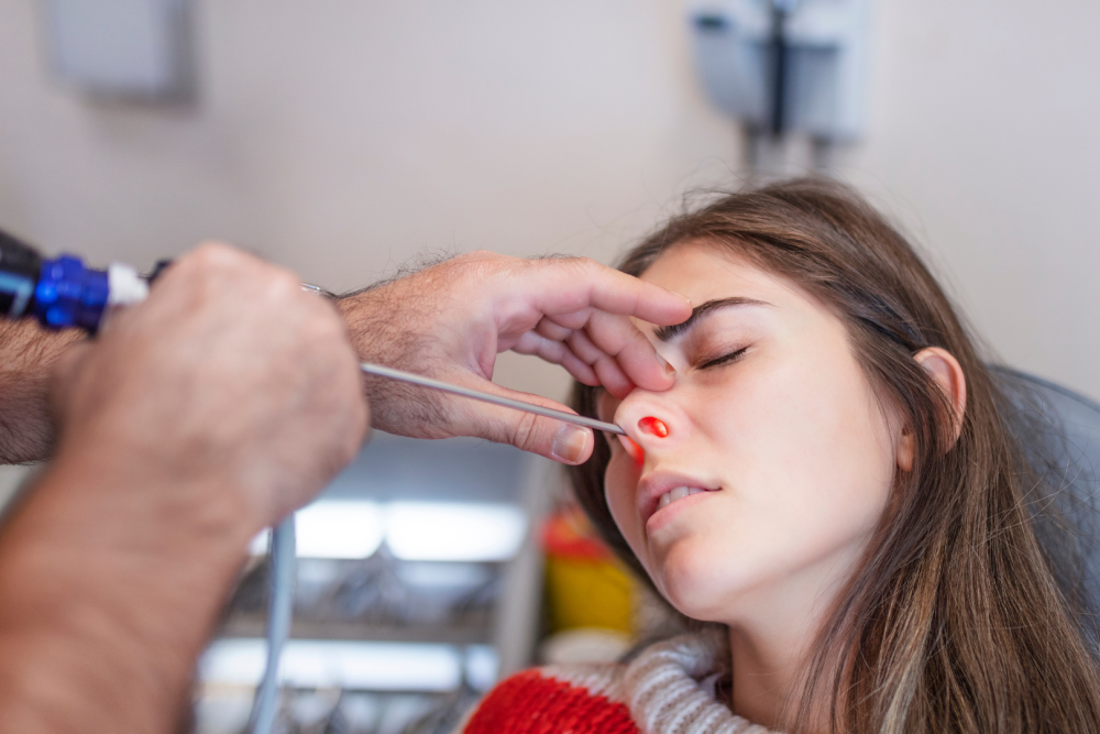Badanie ucha przy użyciu otoskopu w gabinecie medycznym, lekarz trzyma urządzenie diagnostyczne przy przewodzie słuchowym