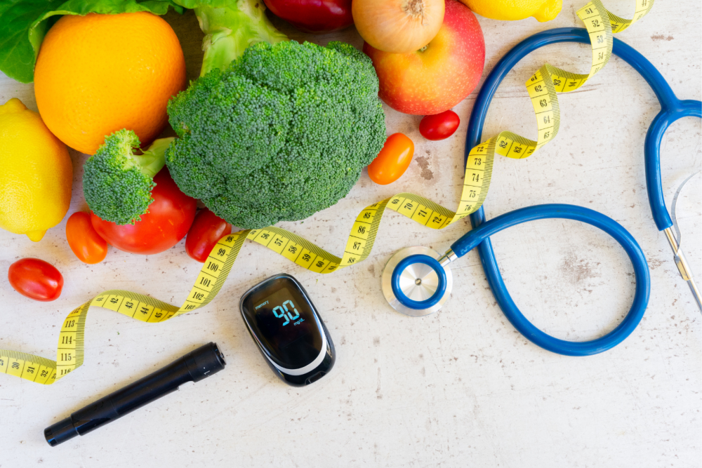 Warzywa i owoce ułożone na blacie obok glukometru, taśmy mierniczej i stetoskopu