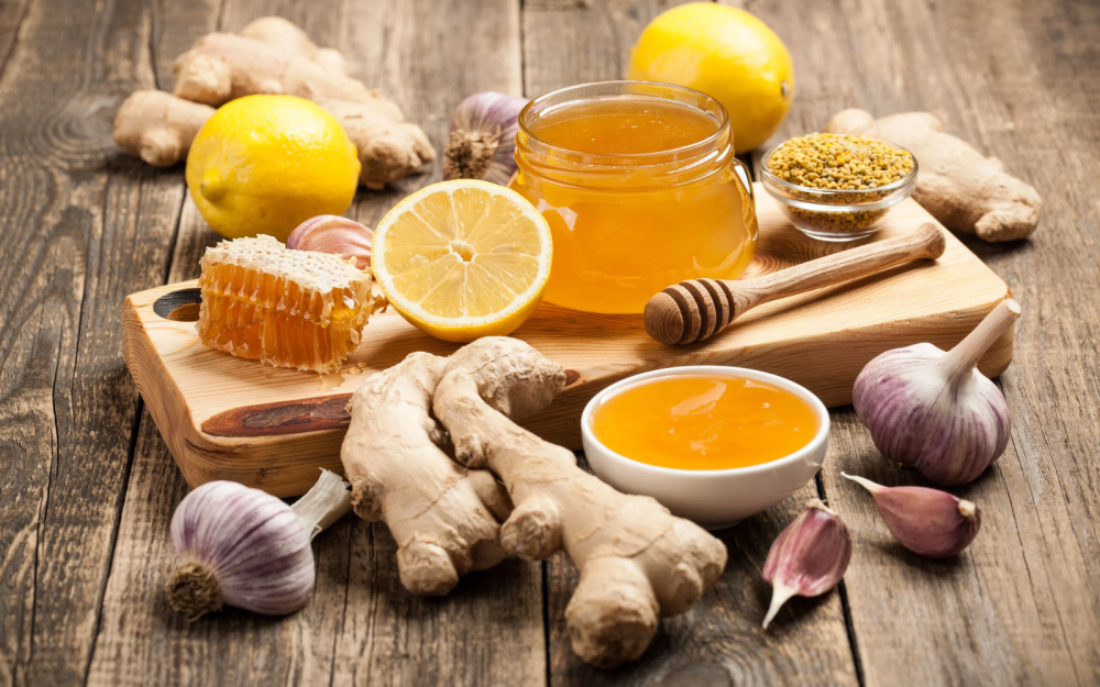 miód, cytryna, imbir i czosnek na desce na stole