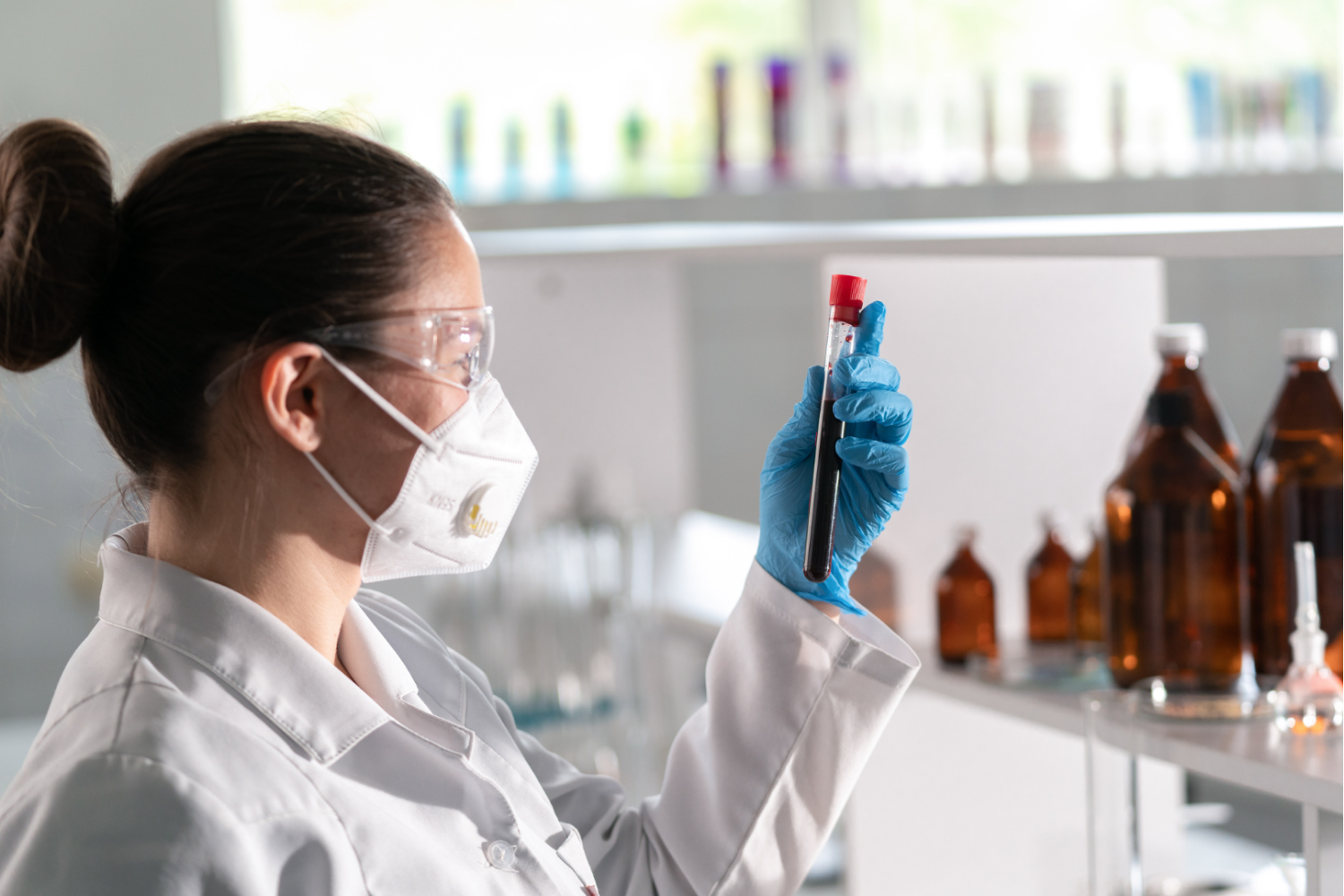 Pracownik laboratorium analizujący próbkę krwi w probówce, obraz przedstawiający diagnostykę laboratoryjną wykonywaną w celu oceny stanu zdrowia i wykrywania skutków zatrucia lub infekcji.
