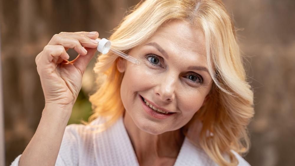 Kobieta trzymająca pipetę od kosmetyku
