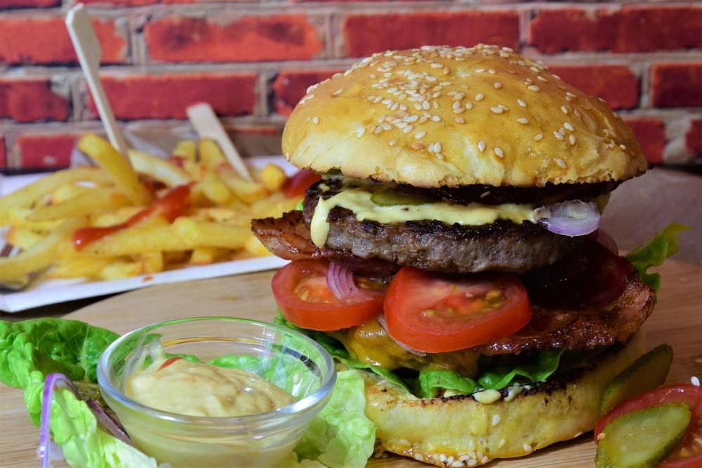 Wielki burger podany z sosem i frytkami