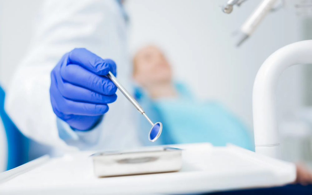 Wizyta u dentysty. Zbliżenie na lusterko stomatologiczne