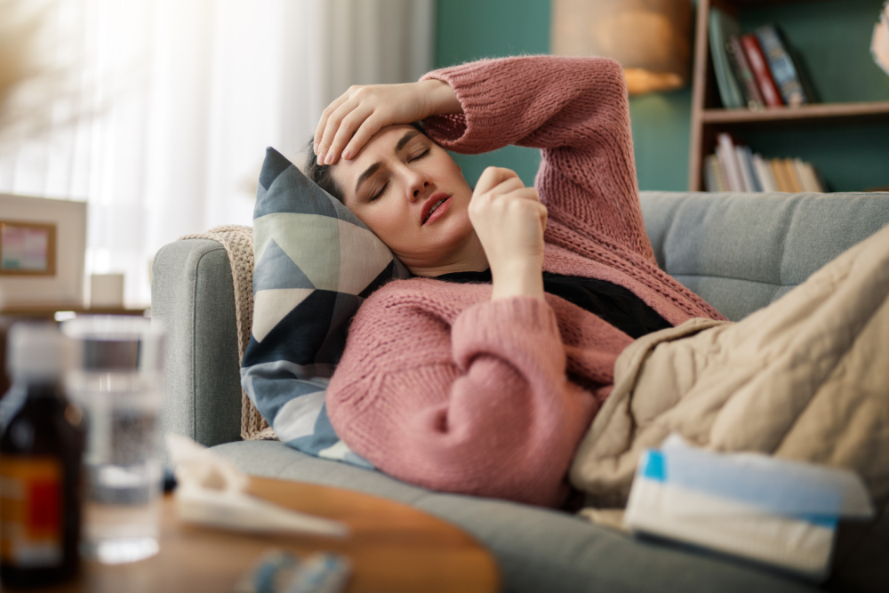 Osoba trzyma dłonie po obu stronach dolnej części twarzy, tło jednolite i jasne