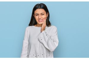 Young hispanic girl wearing casual clothes touching mouth with hand with painful expression because of toothache 