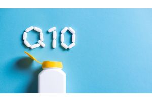 Napis q10 z tabletek ułożony na niebieskim tle