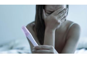 Załamana kobieta trzyma test ciążowy