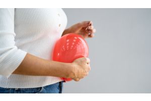 Kobieta trzyma nadmuchany balon przy brzuchu