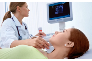 Badanie USG tarczycy wykonywane w gabinecie lekarskim, głowica ultrasonograficzna przykładana do szyi pacjenta, obraz przedstawiający diagnostykę chorób tarczycy, w tym Hashimoto, niedoczynności tarczycy oraz zmian w obrębie gruczołu tarczowego.